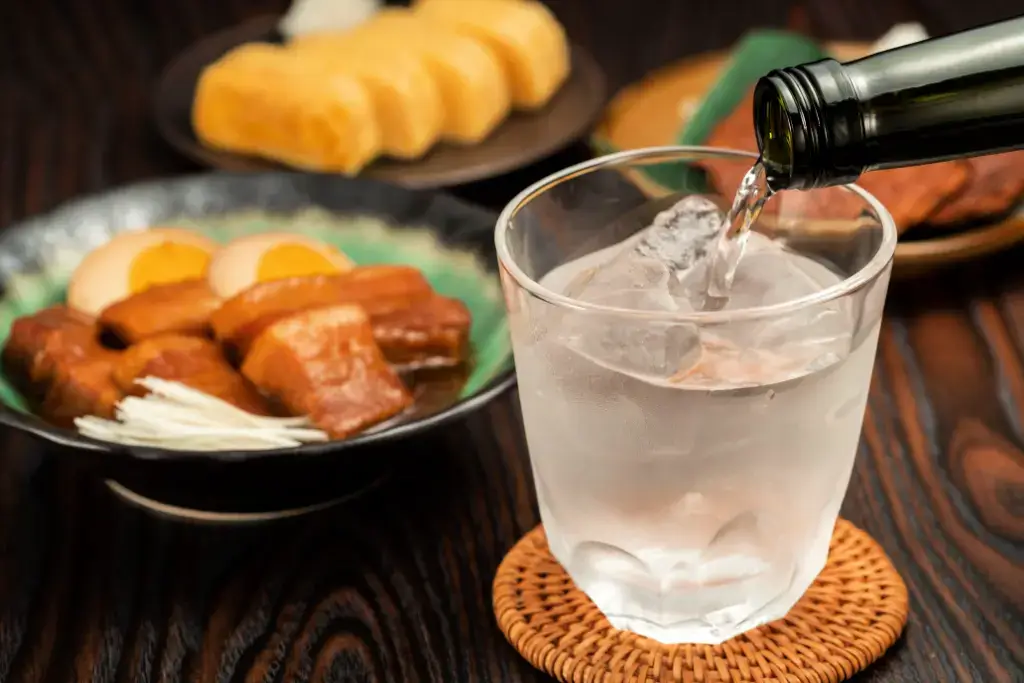 A glass of Japanese alcohol being poured.