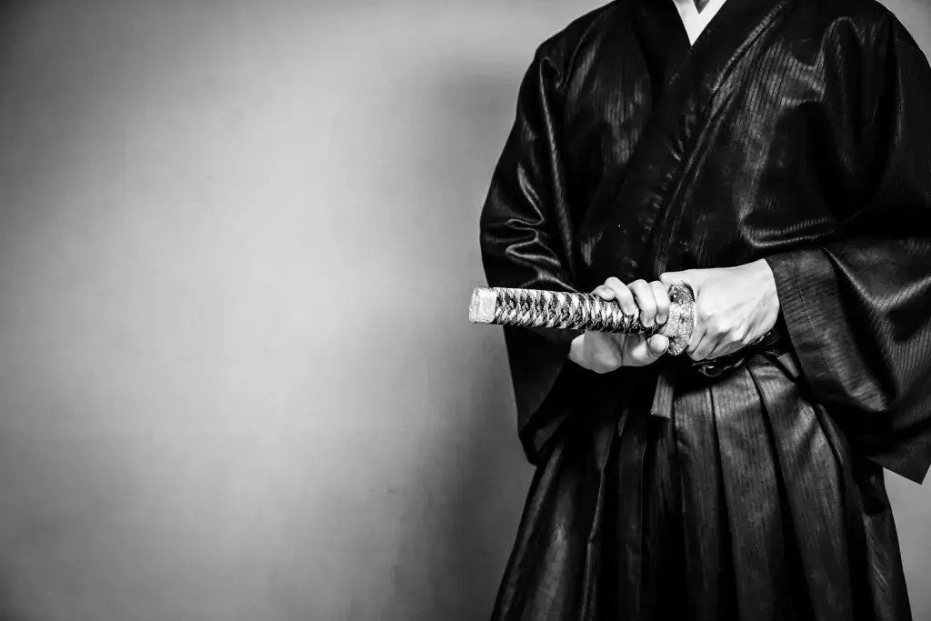 A person in jidaigeki clothing, holding a sword.
