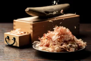 A plate of katsuobushi flakes, with a whole version in the back.