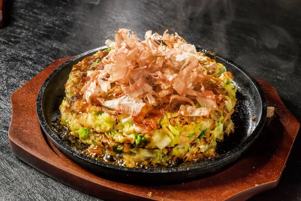 Okonomiyaki with bonito flakes on top.