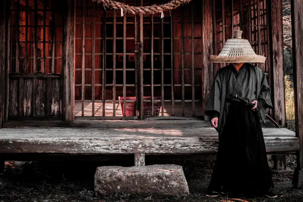 A samurai standing outside of of a medieval jail cell.