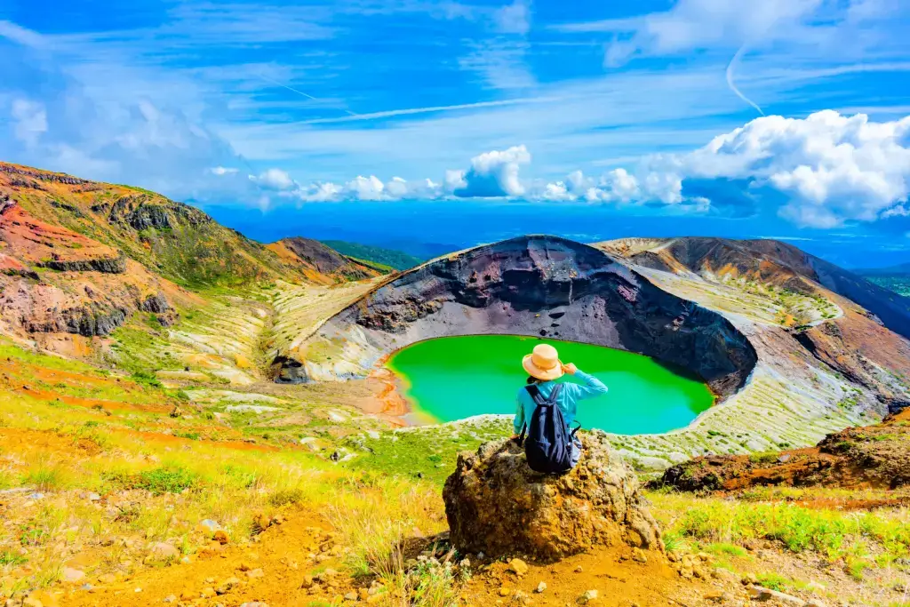A person sitting at Okama Crater in Tohoku, Japan.