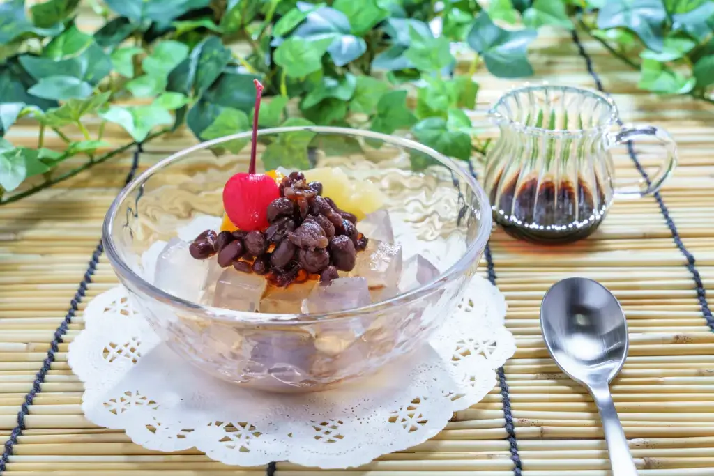 A bowl of a Japanese dessert with fruit and jelly.