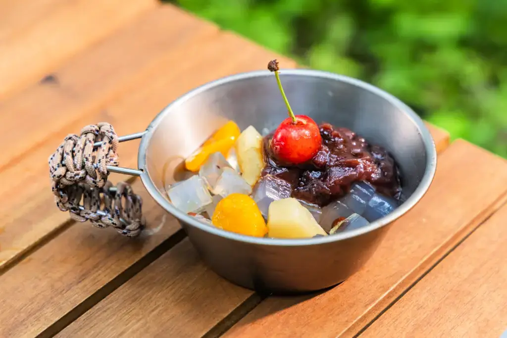 A bowl of anmitsu featuring fruit, kanten jelly and anko.