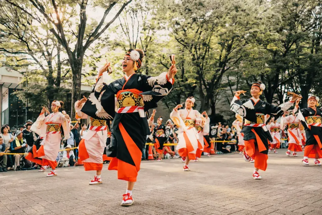 Women in black yukatas doing a dance during Obon season.