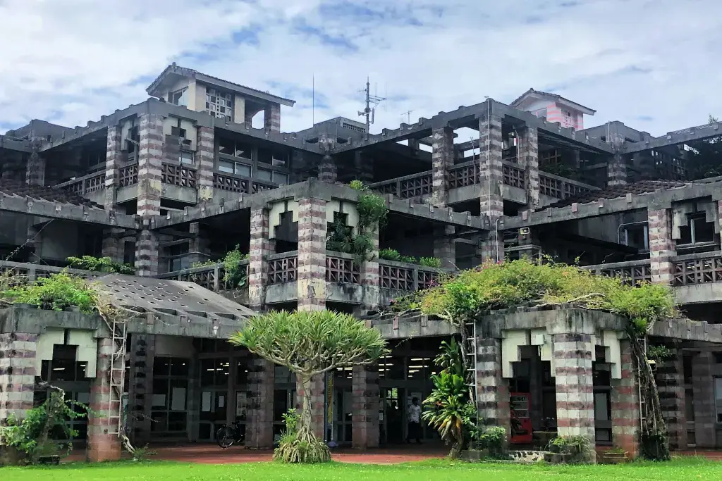 Nago City Hall. It's made of stone and has overgrown ivy.