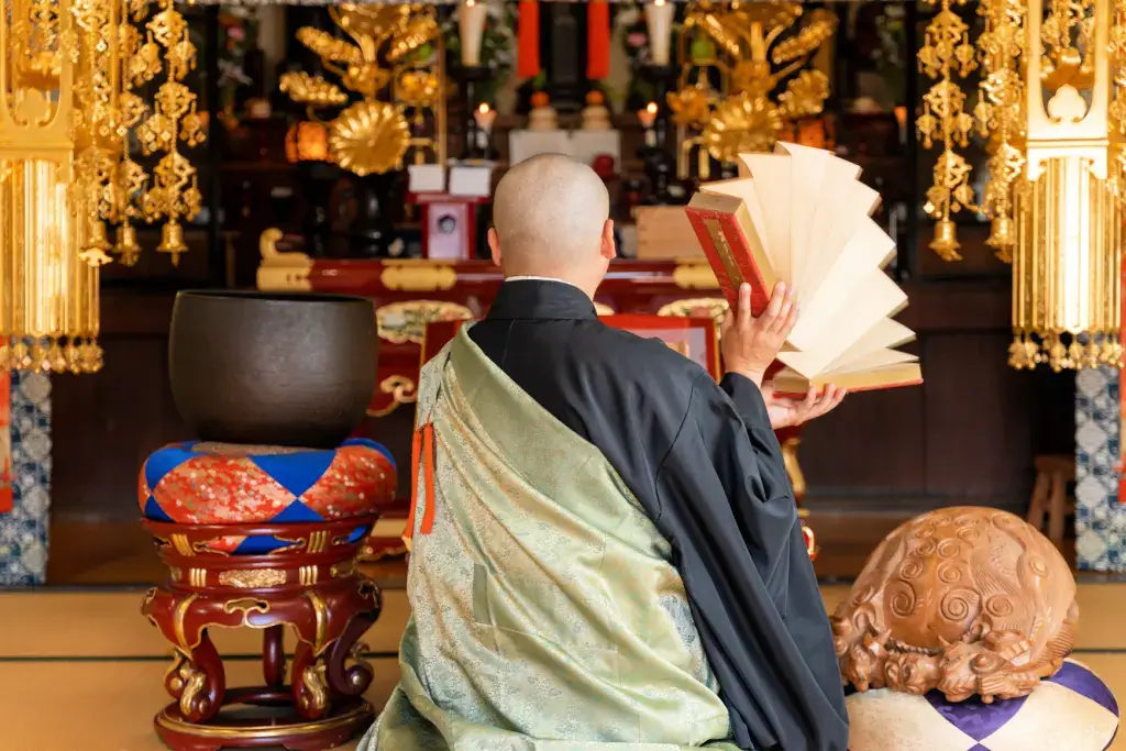 A Buddhist monk opening and closing prayer scrolls.