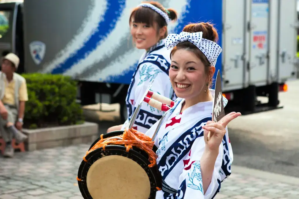 Two women in yukata, parading drums during Obon.