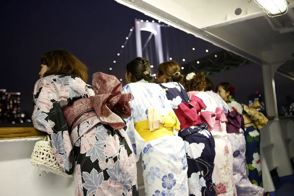 A bunch of women wearing yukata on a boat cruise.