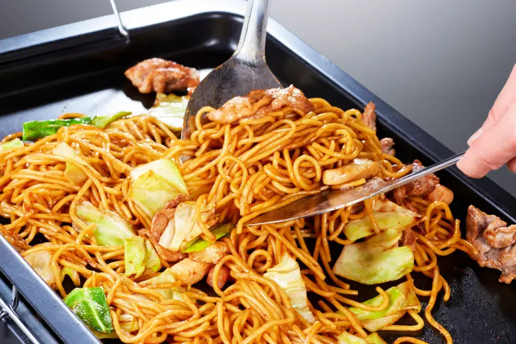 Yakisoba being fried on a griddle.