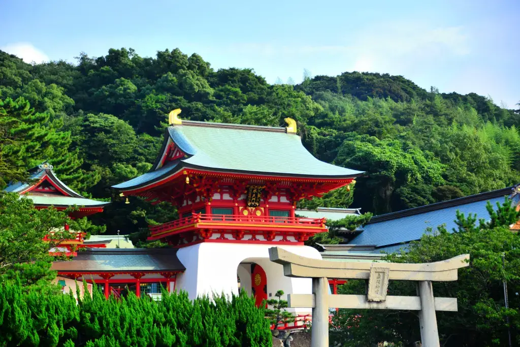 The outside of Akama Shrine. It is red and white with a green roof.