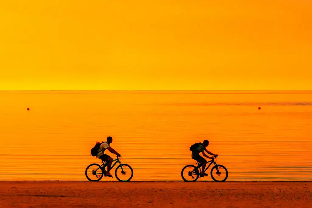 Two people cycling in the sunset.