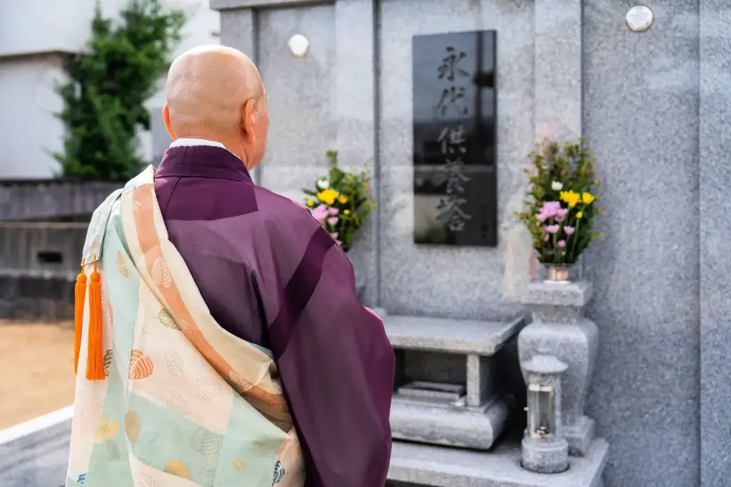 A Buddhist monk at a tombstone.