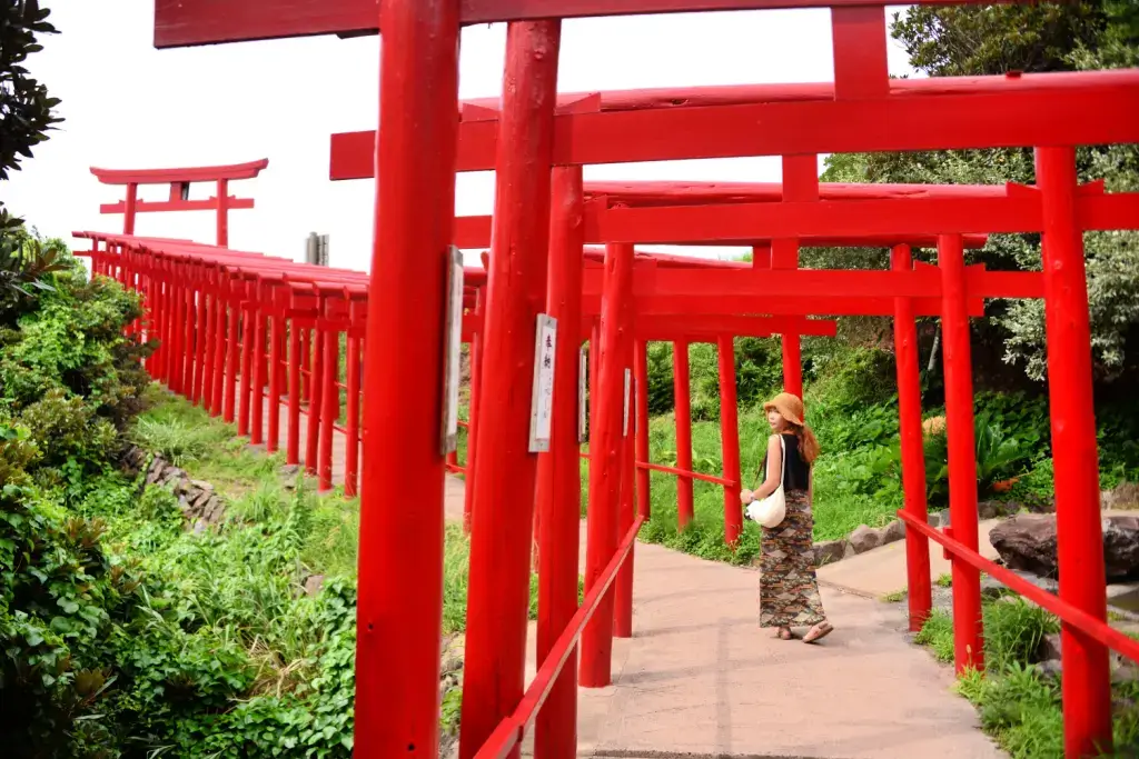 A woman at the red torii gates of Motonosumi Shrine in Yamagata Prefecture.