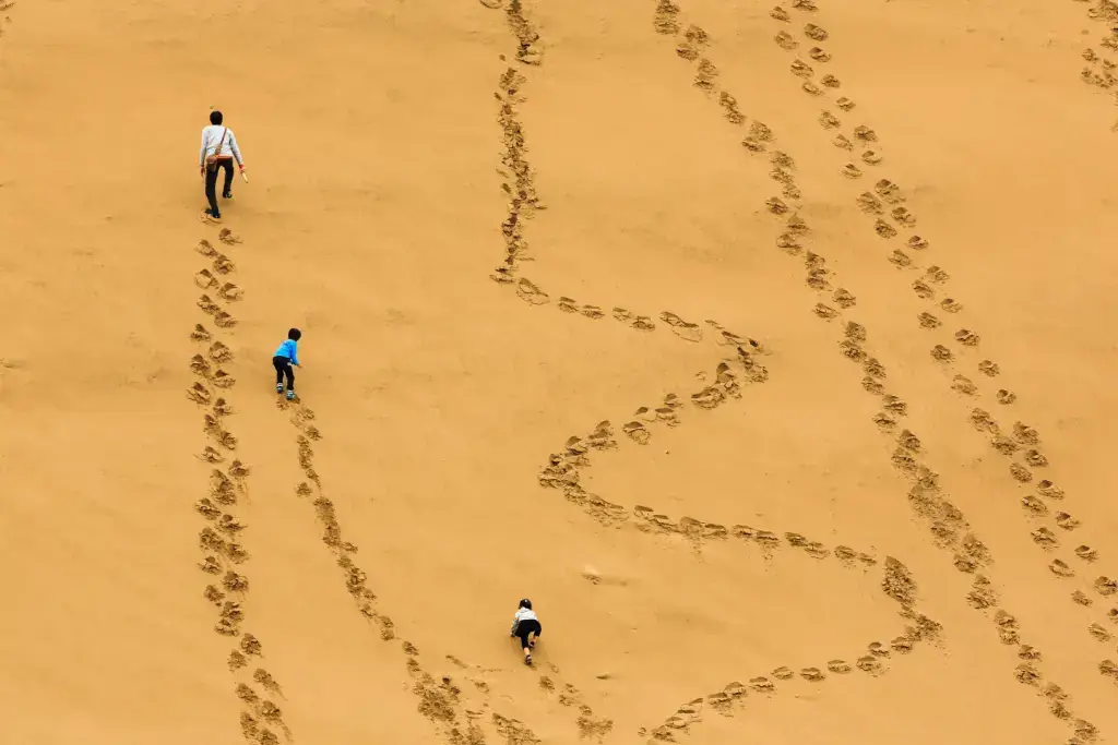 People walking and leaving footprints in the Tottori Sand Dunes.