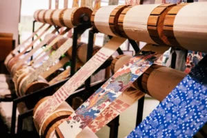 A bunch of different kimono silks on a wooden structure for crafting purposes.