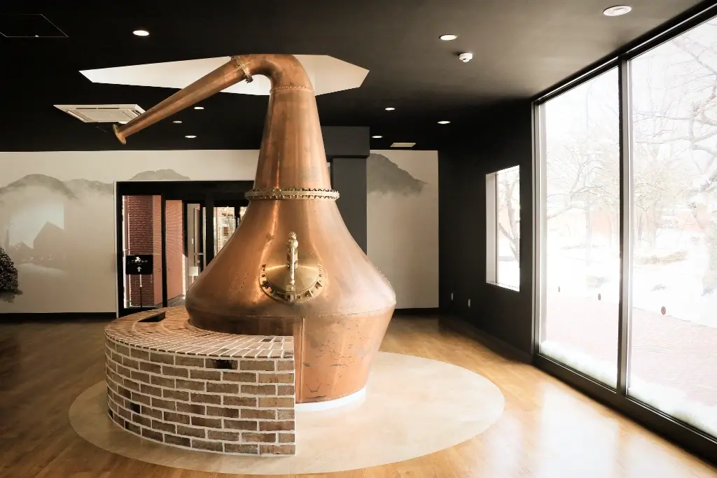 The Miyagikyo Distillery interior. There's a large brass bottle sculpture in the middle.