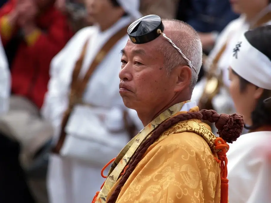 An elderly man wearing a tokin (a small round hat) at a festival.