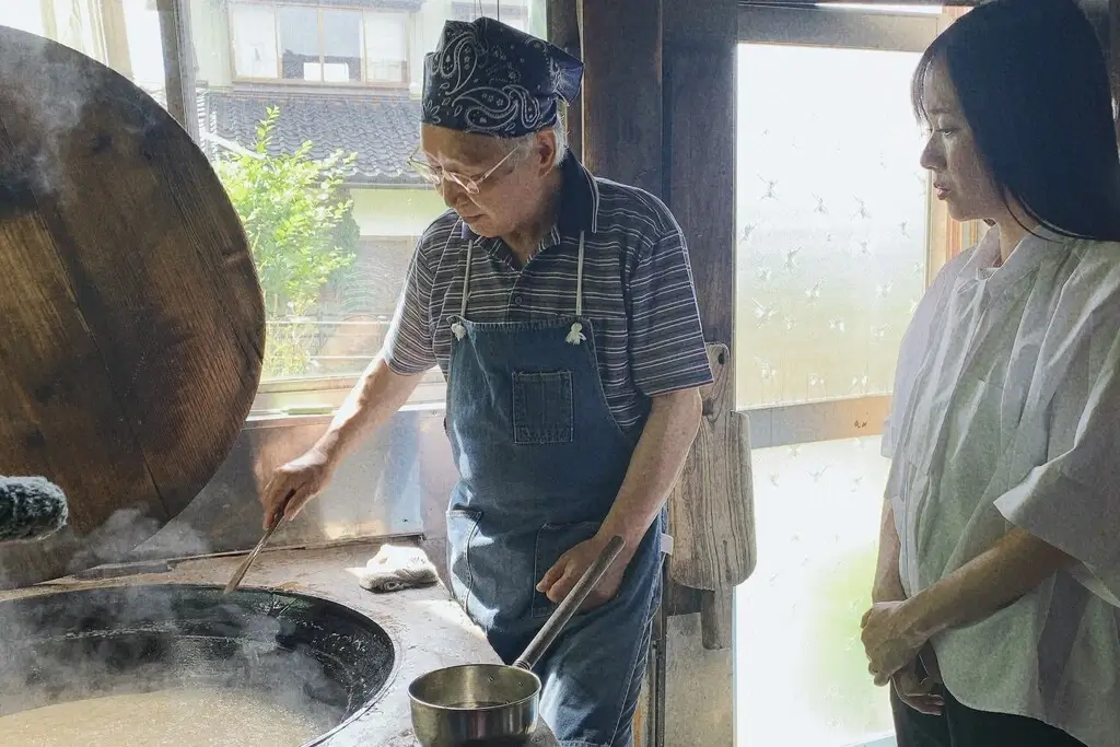 Ayumi Chikamoto observing Yuki Yokoi making artisanal brown rice candy.