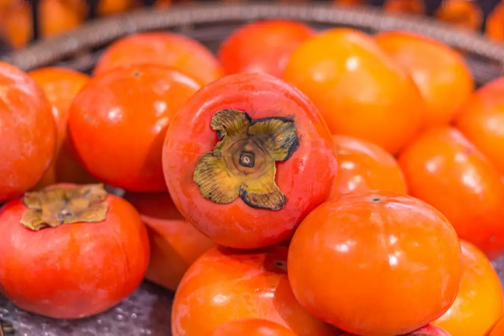 A pile of persimmons on a table.