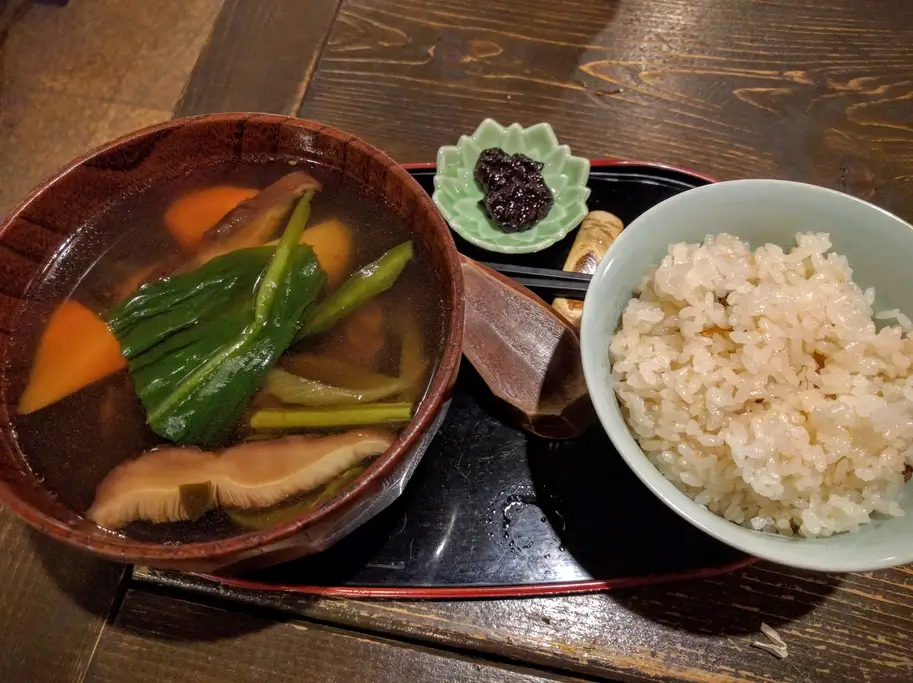 A bowl of sayo porridge next to some soup.