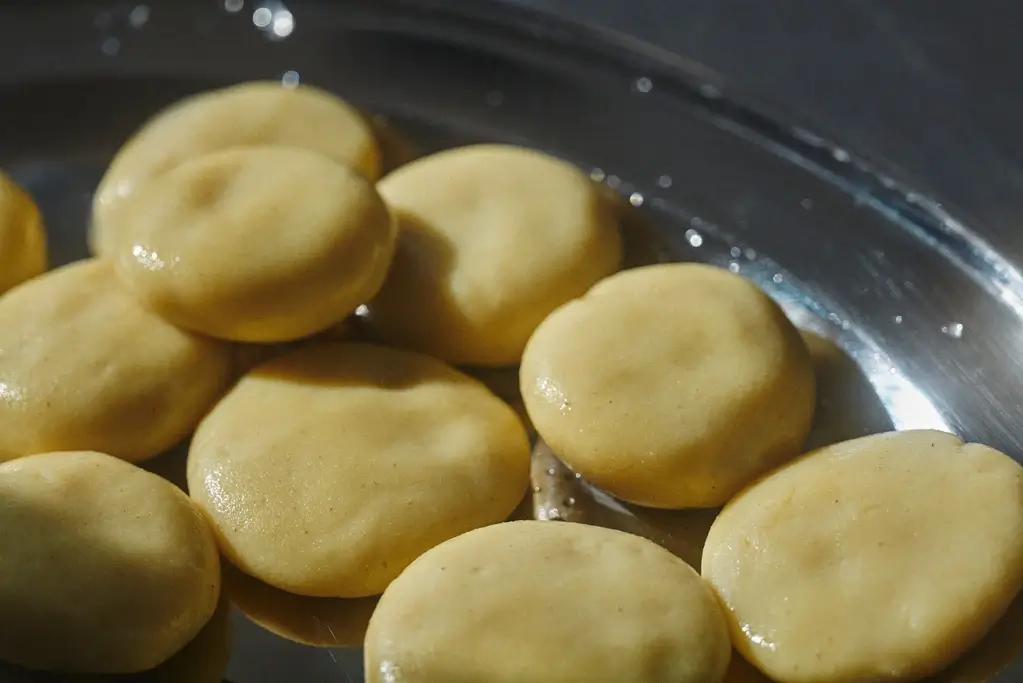 A bunch of sito dumplings in a pan.