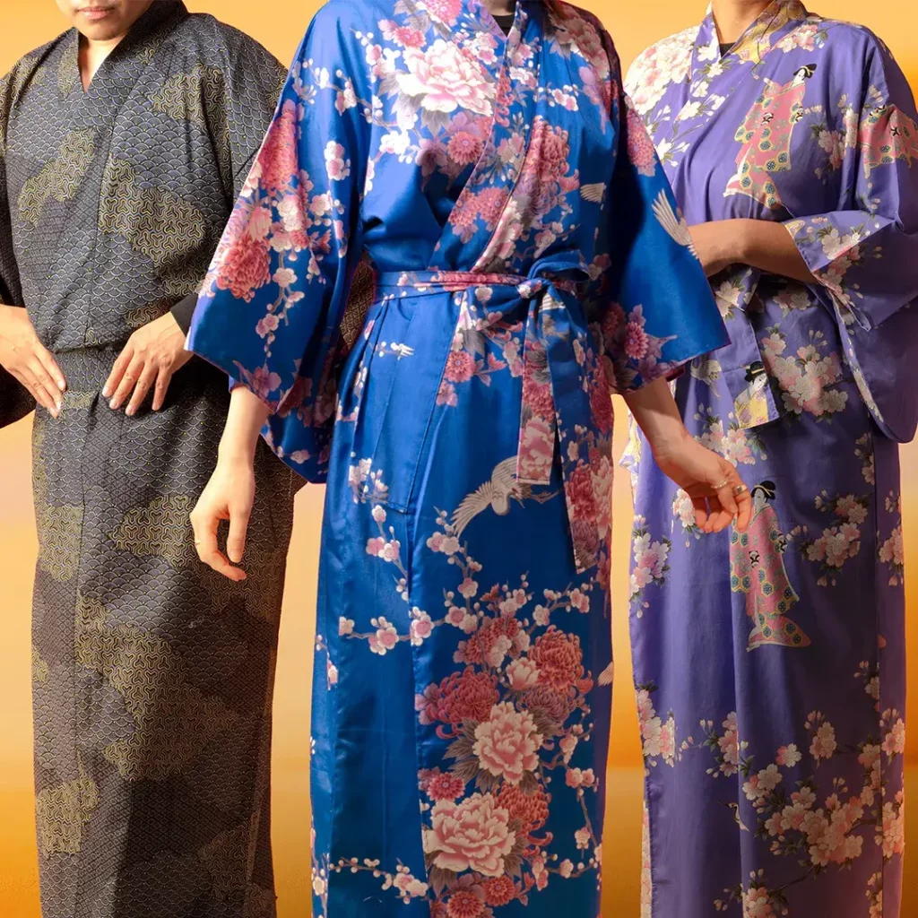 Three people wearing comfortable kimono robes: gray/beigs, royal blue with florals, and light purple with florals.