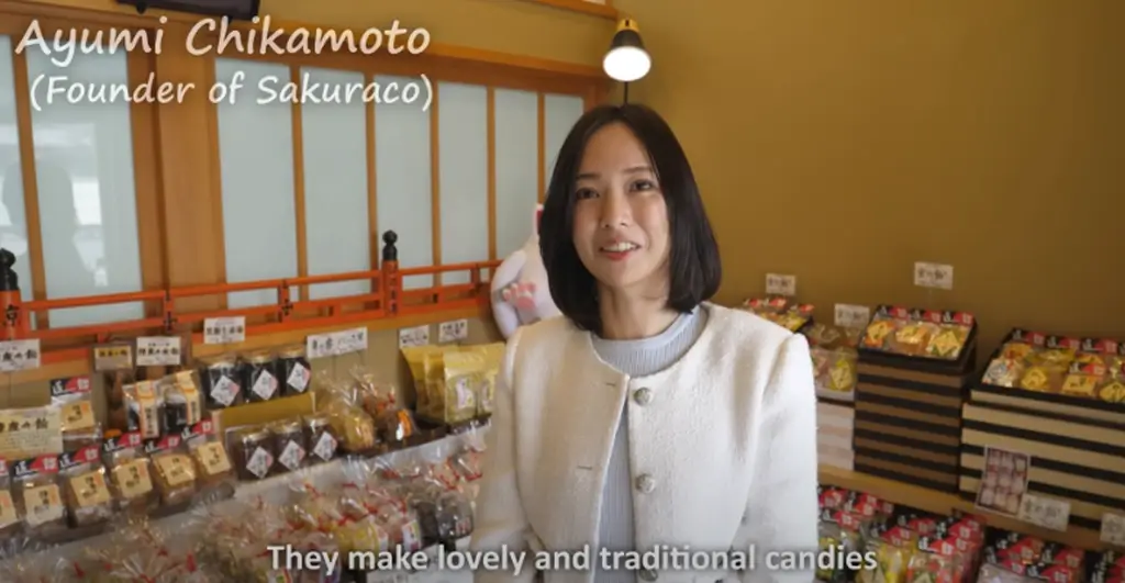 Ayumi Chikamoto, the CEO of Sakuraco. She is wearing a white cardigan. 