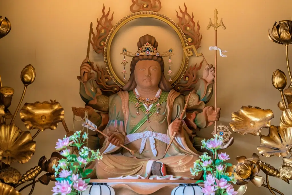 A clay statue of Benzaiten in a shrine. She has a round faace.