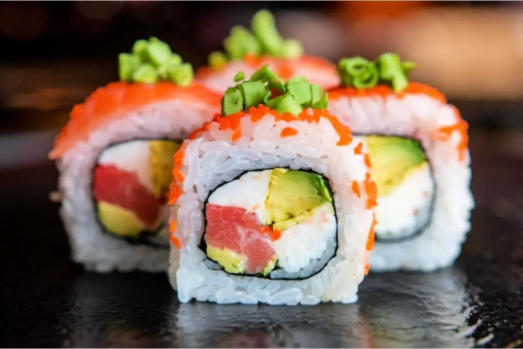 Three slices of California Roll sushi.