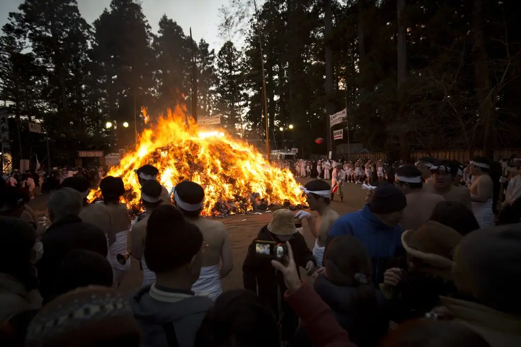 People sitting around a bonfire at the Dontosai Festival.