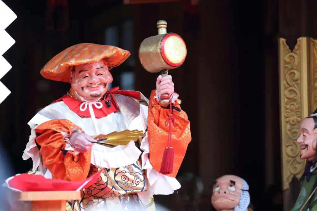 A statue of Ebisu. He wears a red hat and holds a mallet.