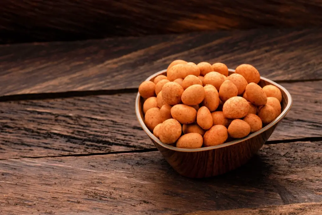 A bowl of orange Japanese peanuts.