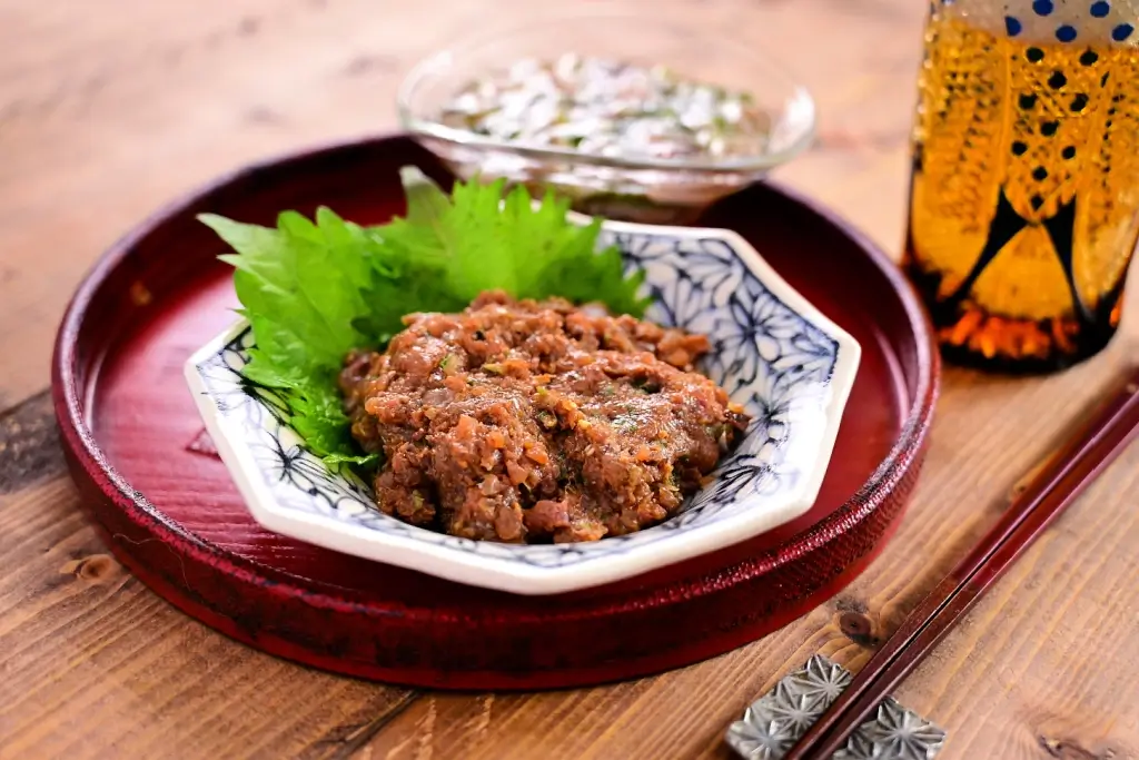 A plate of namero (disced fish and onion) and shiso leaf on a plate.