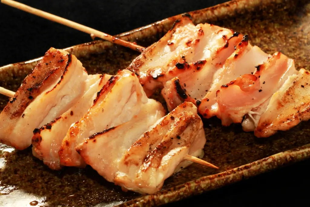 A plate of grilled chicken cartilage on skewers.