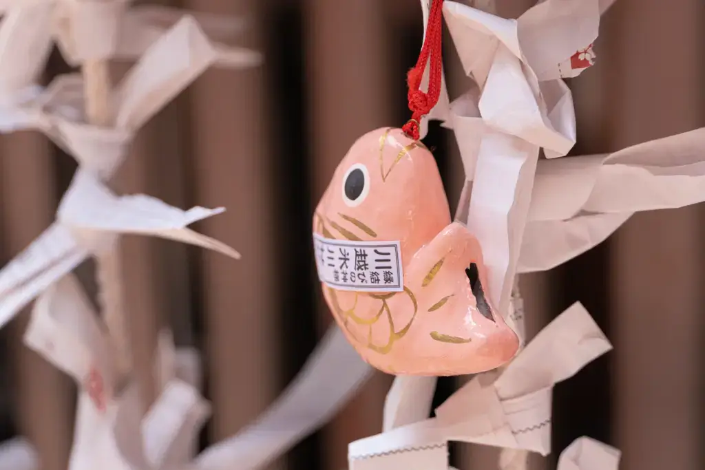 A wooden frog charm hanging near a shrine.