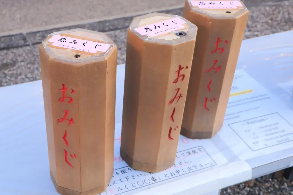 Three wooden cylinders containing omikuji.