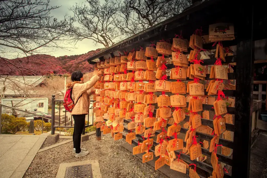 A person writing a wih near a bunch of wooden boards.