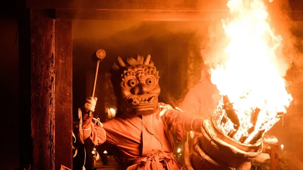 Someone dressed in an oni mask, holding a torch at the Oni Hashiri Festival.