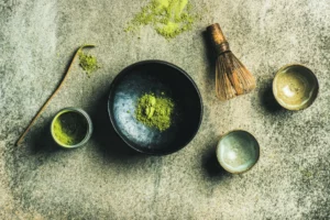 A plate of rare green tea powder, surrounded by wooden tea utensils.