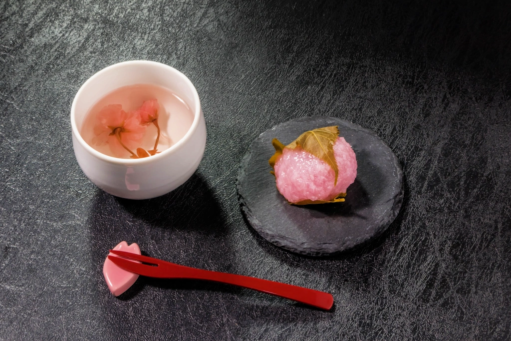 A cup of sakura tea and a plate of sakura mochi.