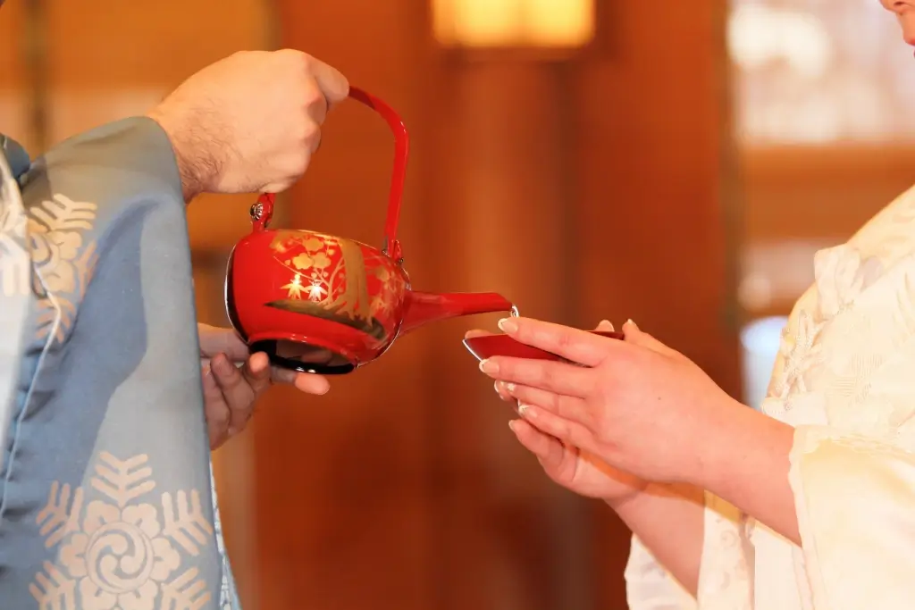 Someone pouring sake for the Japanese wedding ritual for "san san ku do".