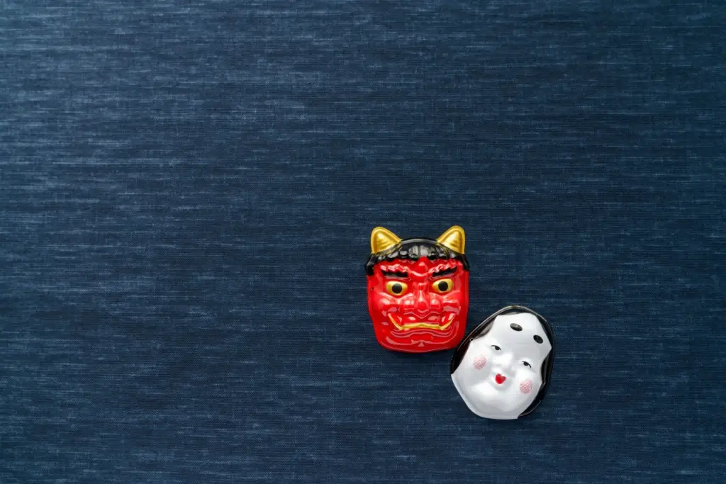 An oni and Noh porcelain mask side by side.