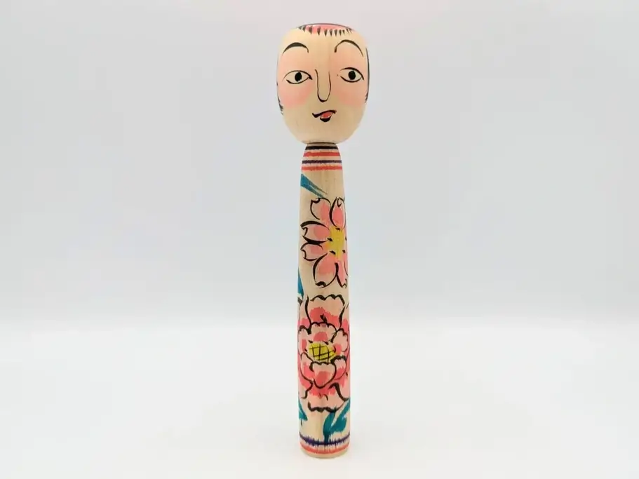 A Nakanosawa Onsen kokeshi doll. It's long, thin with an unusual facial expression with heavy blush.