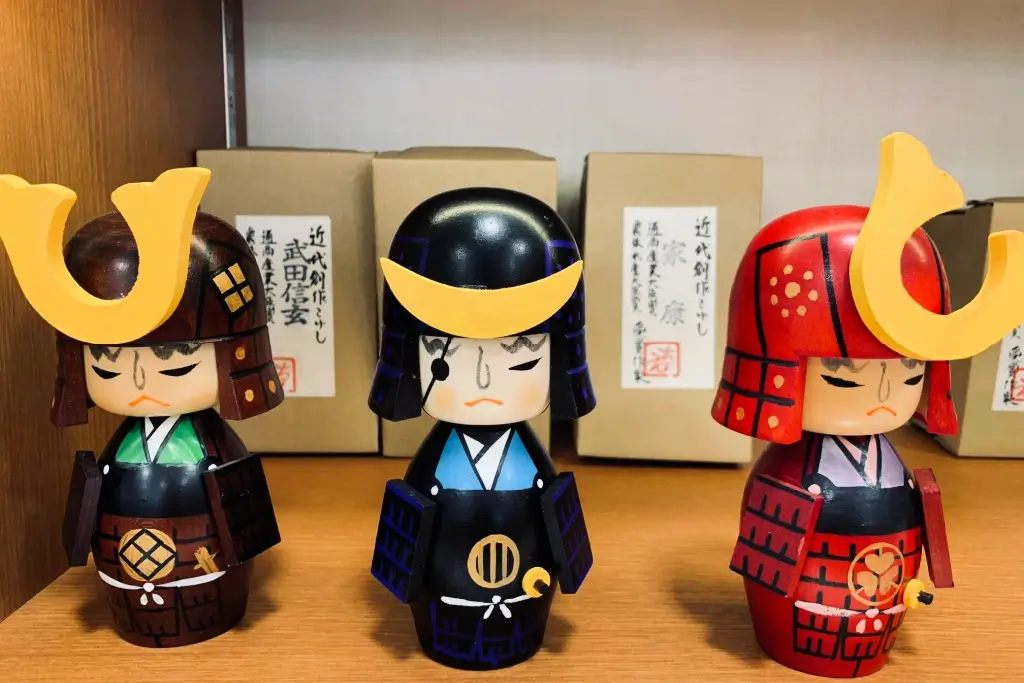 Three samurai kokeshi dolls.