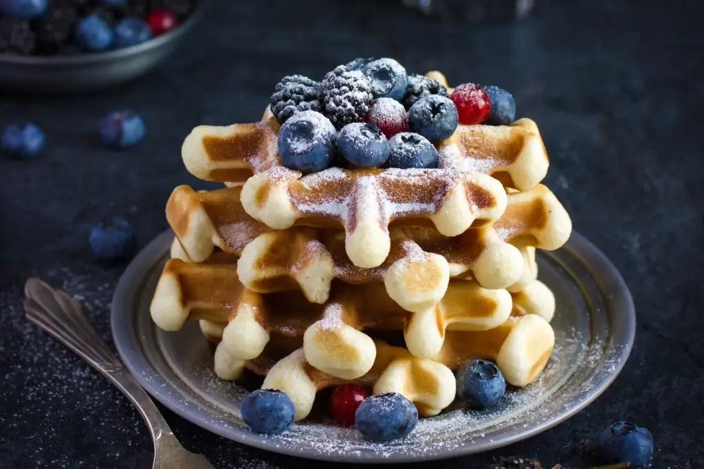 A plate of Belgian waffles with blueberries.