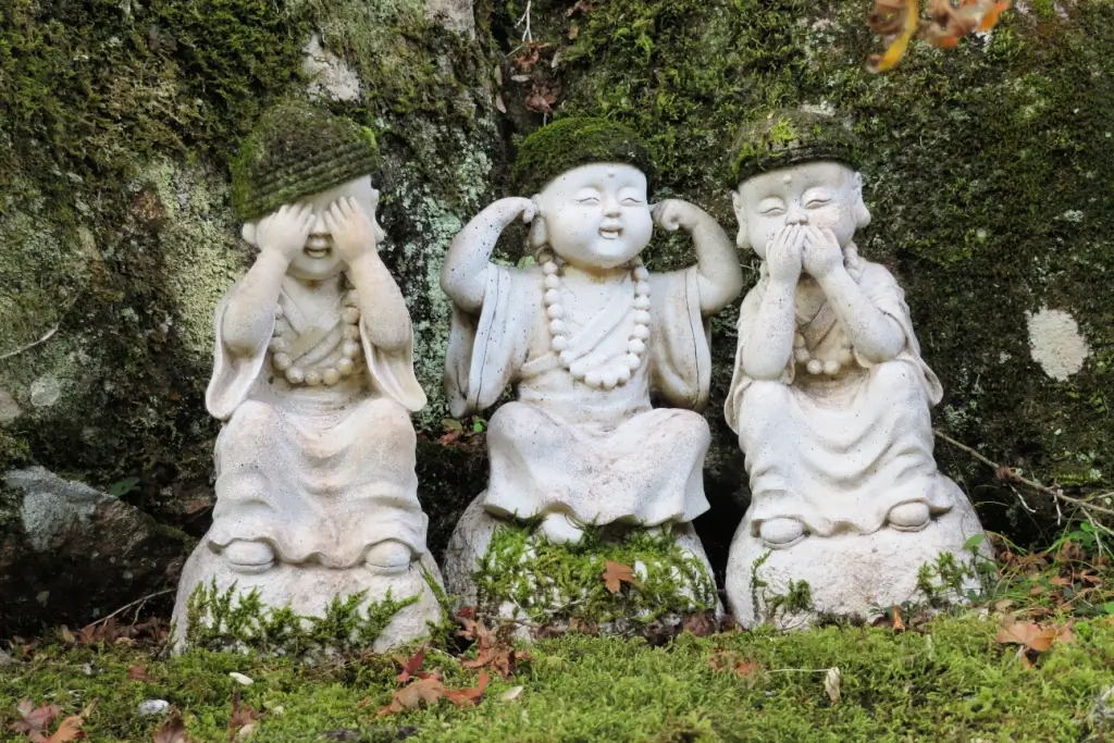 Three baby-like statues depicting the Japanese proverb "see no evil, hear no evil, speak no evil".