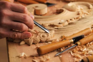 A person whittling a Japanese wood sculpture.