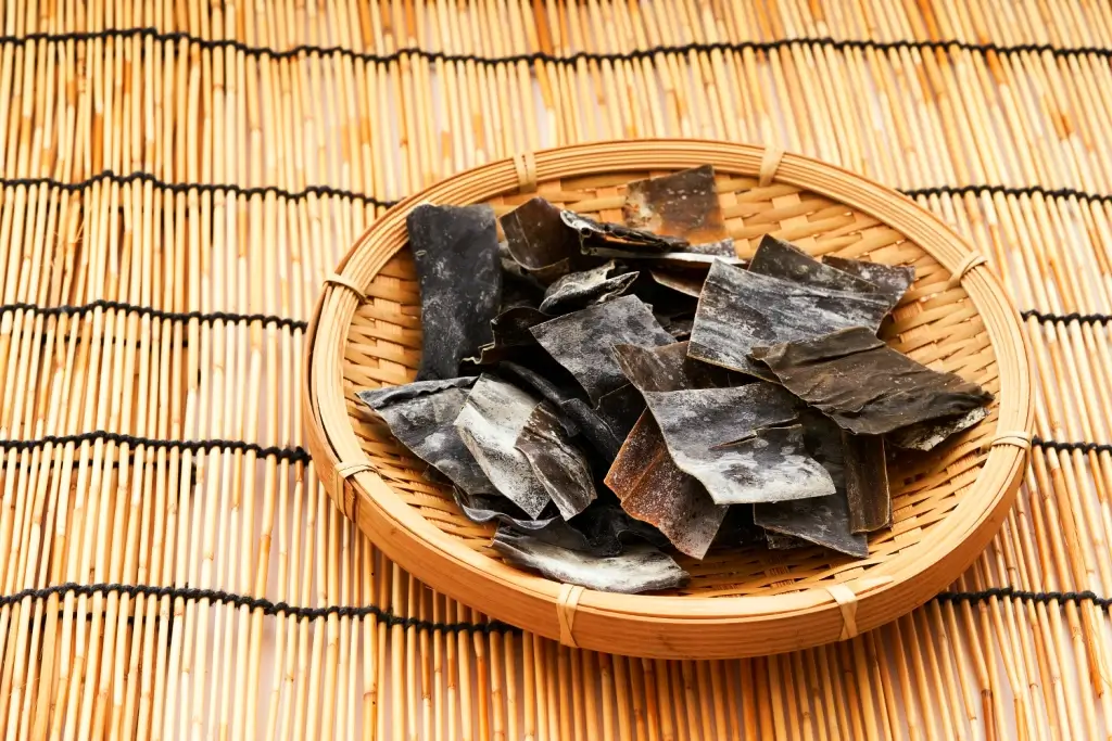 A plate of kombu seaweed on a bamboo sheet.