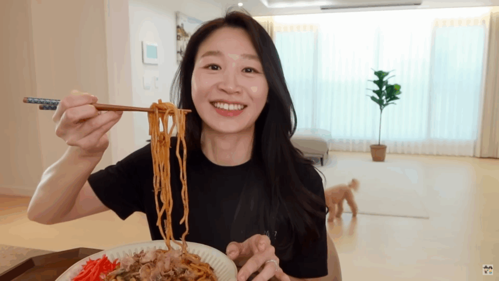 Claire smiling with a plate of their homemade Yakisoba